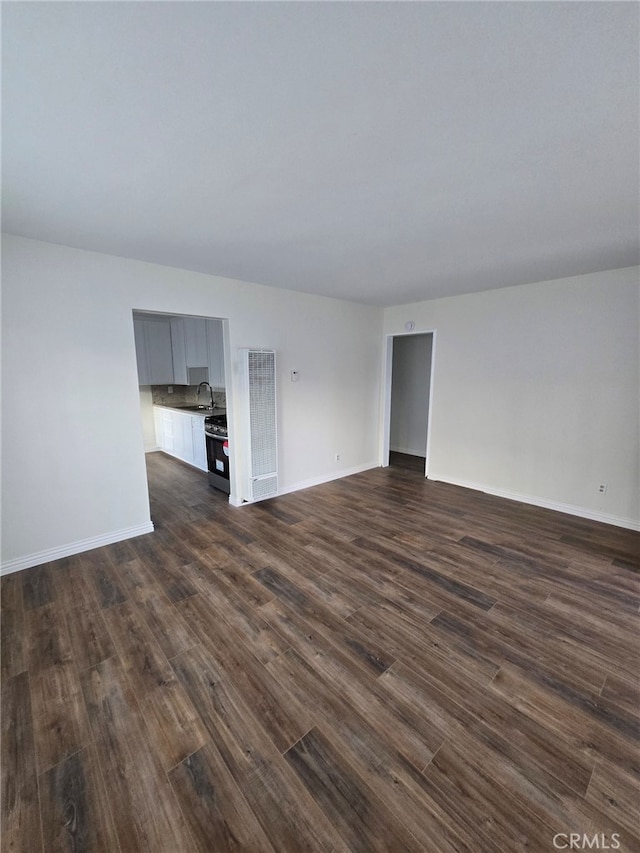 unfurnished living room with dark hardwood / wood-style flooring and sink