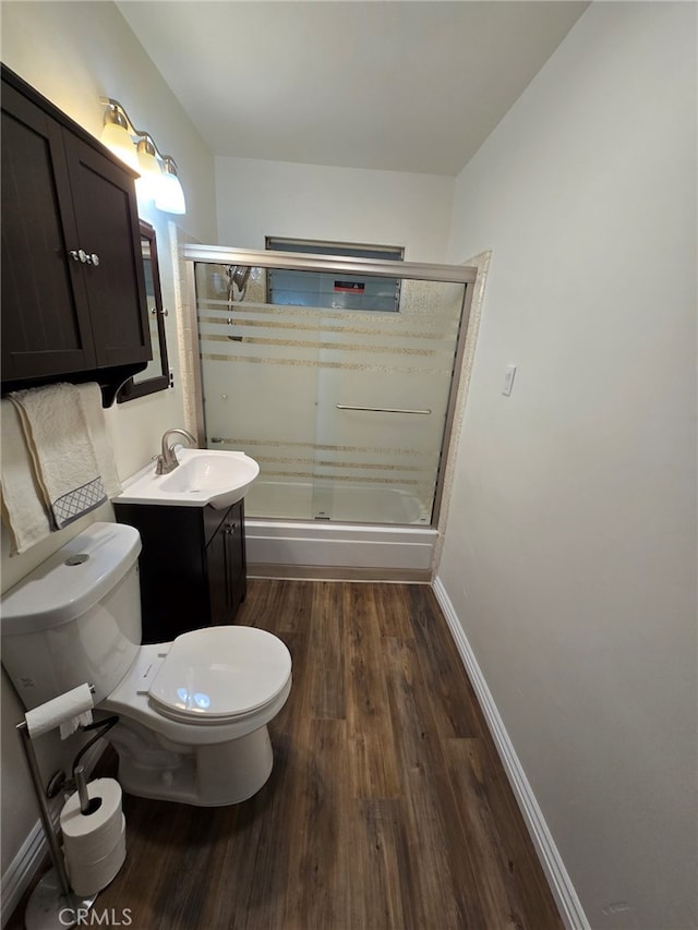 full bathroom with hardwood / wood-style flooring, enclosed tub / shower combo, toilet, and vanity