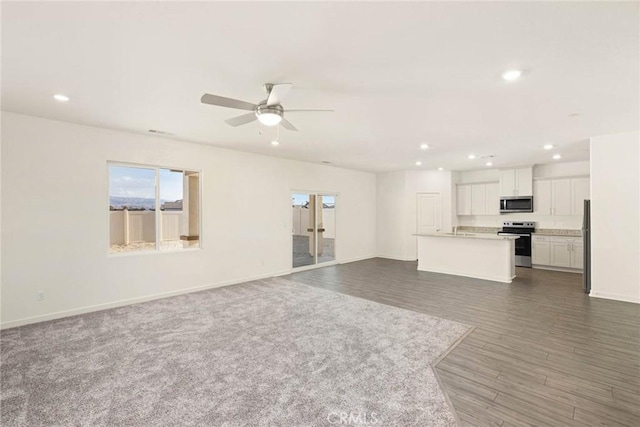 unfurnished living room with ceiling fan and dark hardwood / wood-style floors