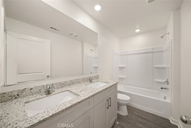 full bathroom featuring bathing tub / shower combination, hardwood / wood-style floors, vanity, and toilet