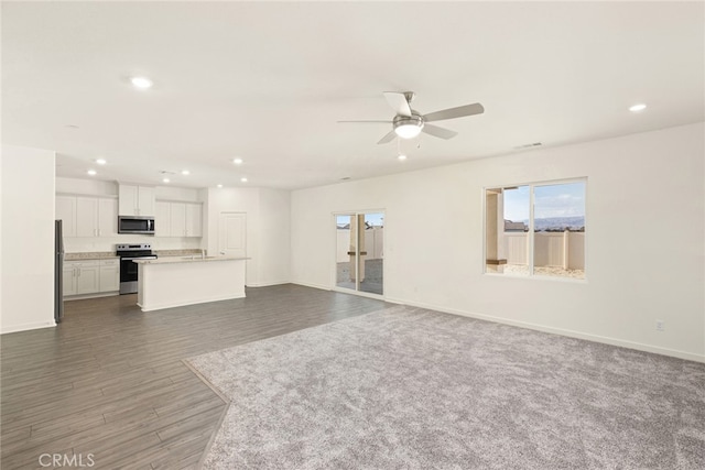 unfurnished living room with dark wood-type flooring and ceiling fan