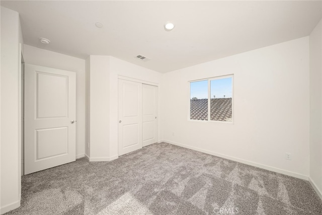 unfurnished bedroom featuring carpet and a closet