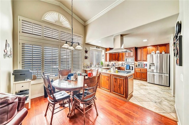 dining area featuring ornamental molding, lofted ceiling, and light wood-type flooring