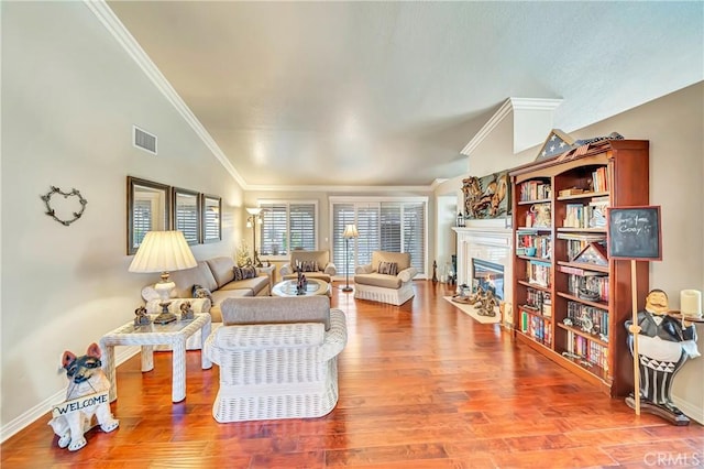 living room with crown molding, lofted ceiling, and hardwood / wood-style flooring