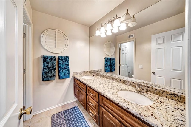 bathroom with toilet, vanity, and tile patterned floors