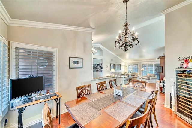 dining area featuring vaulted ceiling, ornamental molding, wine cooler, and hardwood / wood-style flooring