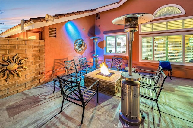 patio terrace at dusk featuring an outdoor fire pit