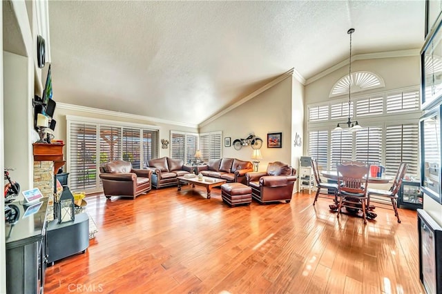 living room with a textured ceiling, hardwood / wood-style floors, an inviting chandelier, and vaulted ceiling