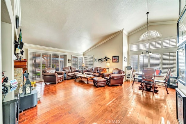 living room featuring lofted ceiling, wood-type flooring, an inviting chandelier, and a textured ceiling