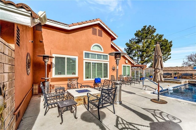 view of patio with an outdoor fire pit and a fenced in pool