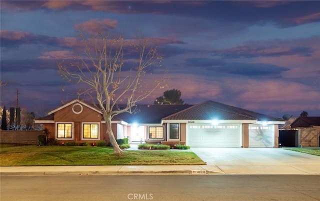 ranch-style home with a garage and a yard