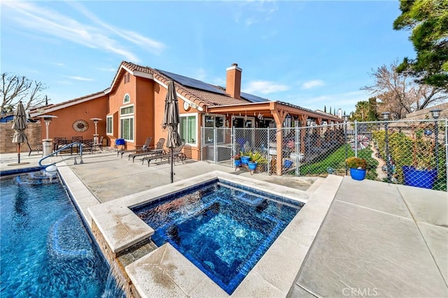 view of swimming pool with pool water feature, a patio, and an in ground hot tub