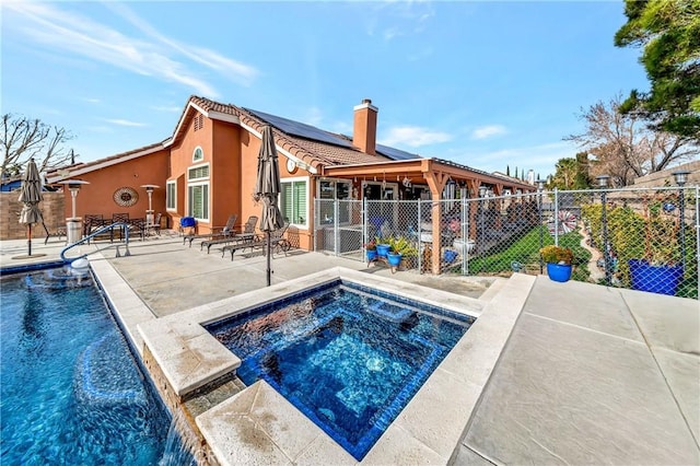 view of swimming pool featuring pool water feature, a patio area, and an in ground hot tub