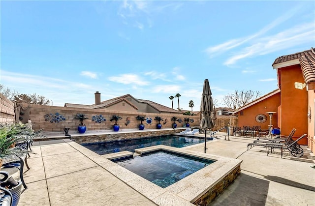 view of pool with a patio and an in ground hot tub