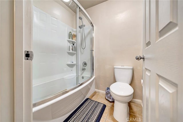 bathroom featuring toilet, shower / bath combination with glass door, and tile patterned flooring