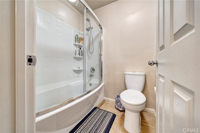 bathroom with toilet, tile patterned floors, and shower / bath combination with glass door