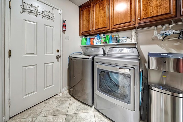 clothes washing area with independent washer and dryer and cabinets