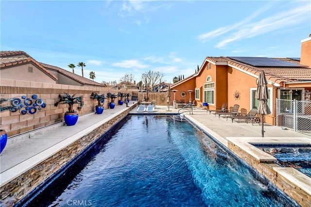 view of swimming pool with pool water feature and a patio area