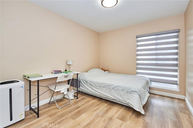 bedroom with multiple windows and light hardwood / wood-style flooring