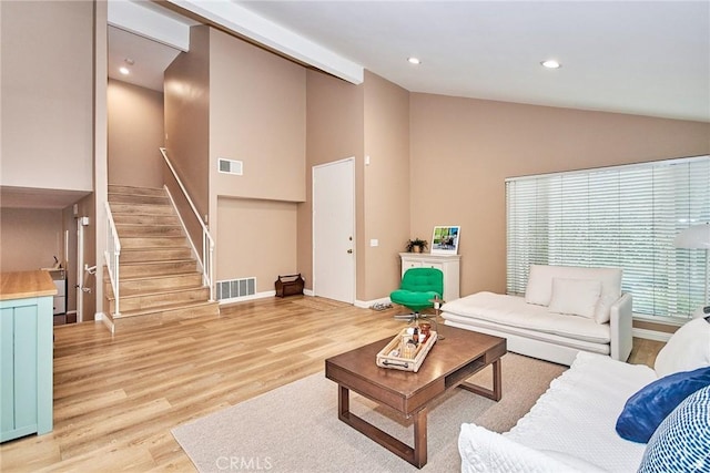 living room with high vaulted ceiling and light hardwood / wood-style floors