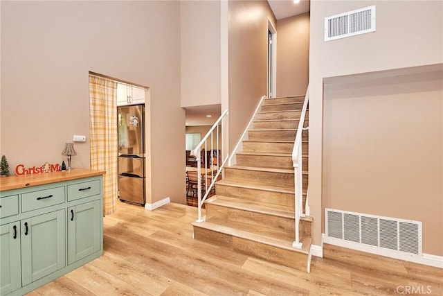 stairway featuring hardwood / wood-style floors and a high ceiling