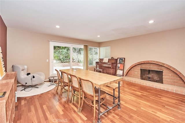 dining area with a fireplace and light hardwood / wood-style flooring