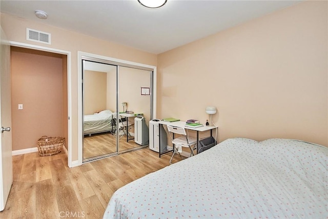 bedroom with light wood-type flooring and a closet