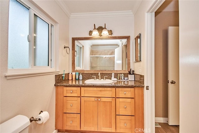 bathroom with crown molding, hardwood / wood-style flooring, vanity, toilet, and walk in shower