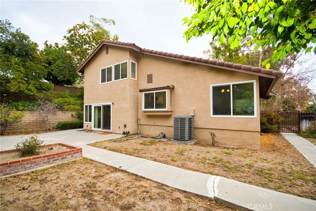 back of house with central AC unit and a patio