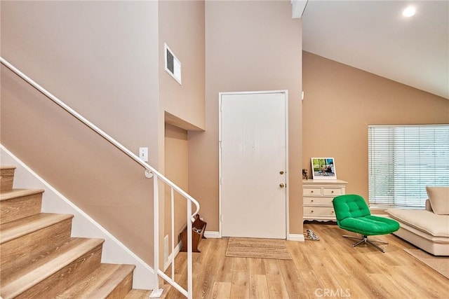 foyer entrance featuring a high ceiling and light wood-type flooring