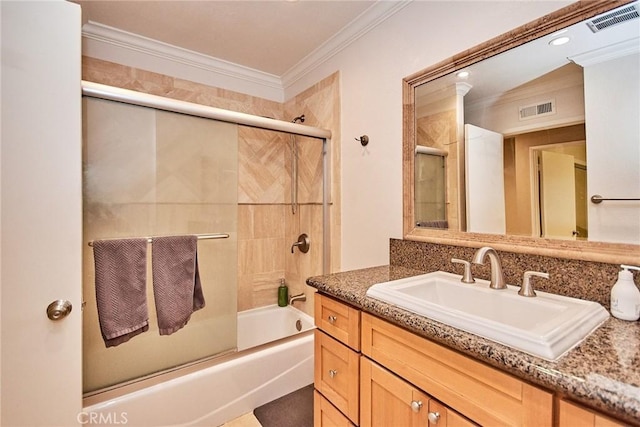 bathroom with crown molding, vanity, and shower / bath combination with glass door