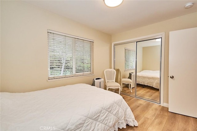 bedroom with a closet and light hardwood / wood-style flooring