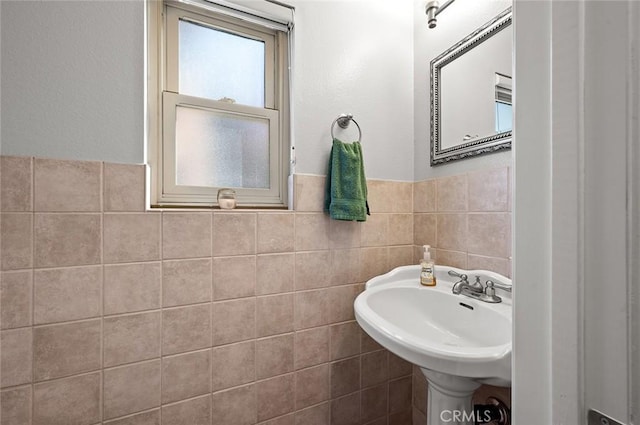 bathroom with sink and tile walls