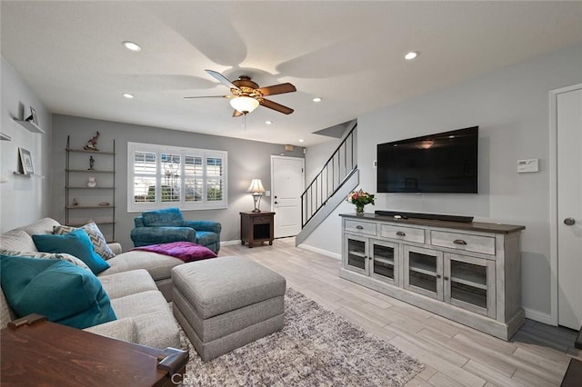 living room with ceiling fan and light hardwood / wood-style flooring