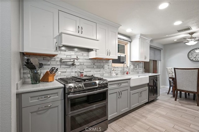 kitchen featuring gray cabinets, ceiling fan, appliances with stainless steel finishes, light hardwood / wood-style flooring, and sink