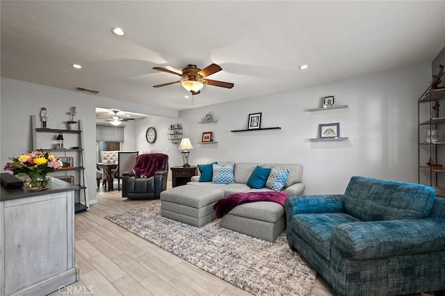 living room featuring ceiling fan and light hardwood / wood-style floors