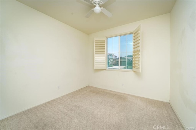 empty room with ceiling fan, light colored carpet, and vaulted ceiling