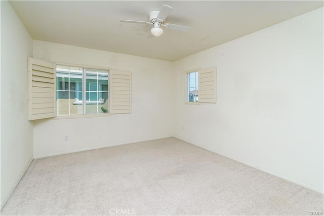 spare room featuring light carpet and ceiling fan