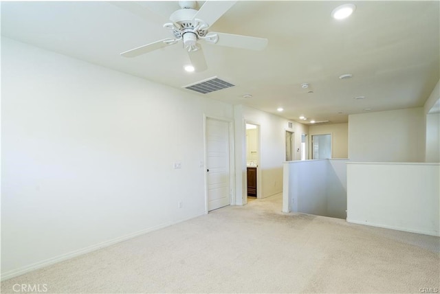 spare room with ceiling fan and light colored carpet