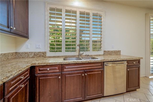 kitchen featuring light stone countertops, sink, light tile patterned floors, and dishwasher