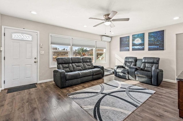 living room with ceiling fan, dark hardwood / wood-style floors, and a wall unit AC