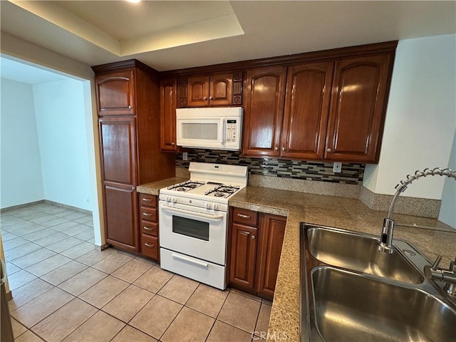 kitchen with backsplash, a raised ceiling, sink, white appliances, and light tile patterned floors