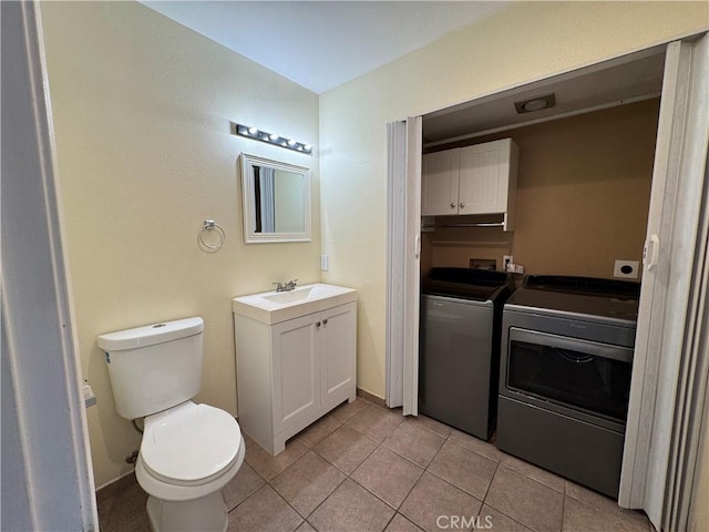 bathroom featuring baseboards, toilet, tile patterned flooring, vanity, and separate washer and dryer