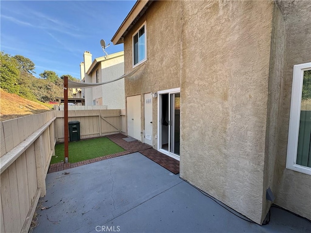 exterior space featuring a patio area, a fenced backyard, and stucco siding