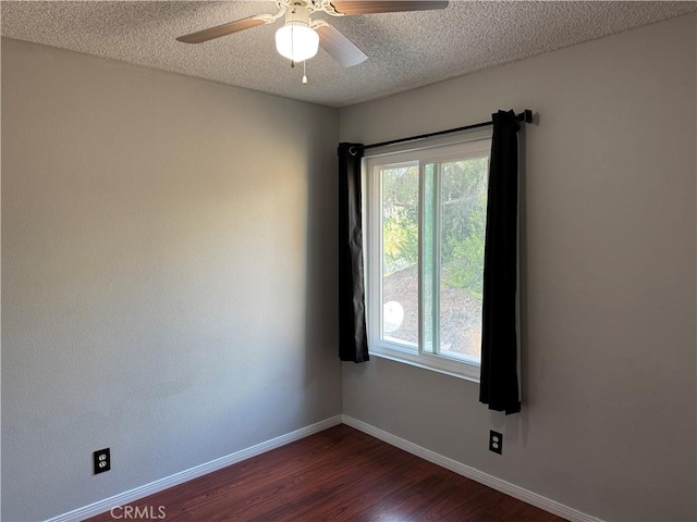 empty room featuring dark wood-style floors, a textured ceiling, baseboards, and a ceiling fan