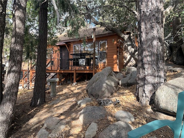 rear view of house featuring a wooden deck