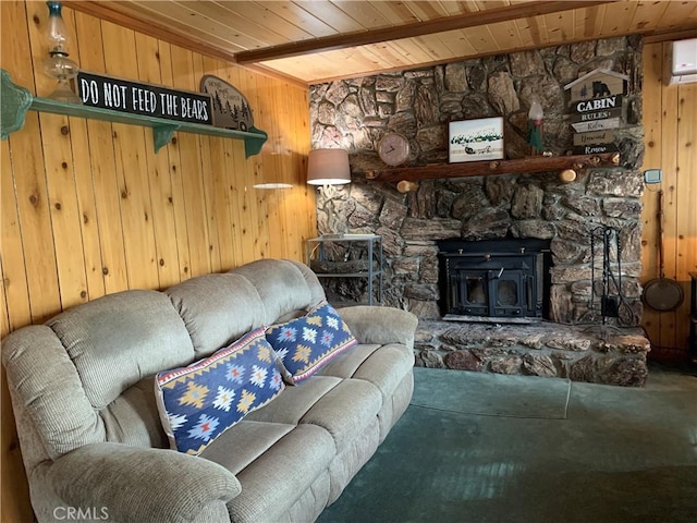 living room featuring wooden walls, a wood stove, and wooden ceiling