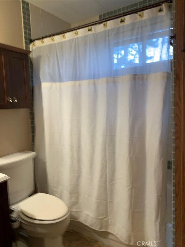 bathroom with toilet, vanity, and curtained shower