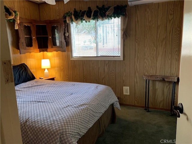 bedroom featuring wood walls and dark colored carpet