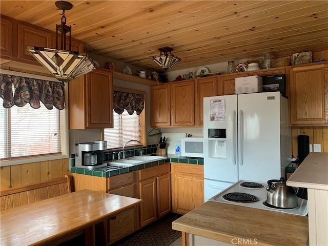 kitchen featuring white appliances, tile counters, decorative light fixtures, sink, and wooden ceiling